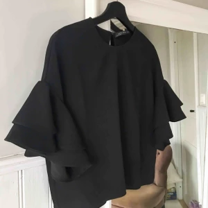  - Svart blus med volang i armarna från zara i storlek xs