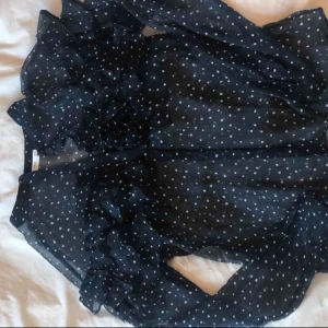  - Prickig mörkblå blus med volanger 