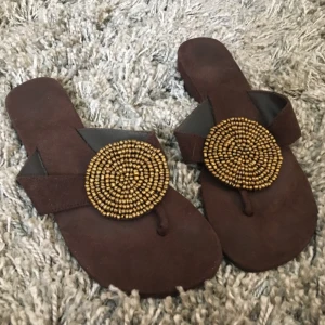  - superfina sandaler från kap verde i brun fake-mocka dekorerade med guldiga pärlor. använda 2-3 ggr. hämtas i sthlm eller skickas om du betalar frakt. säljer massor (kmr mycket nytt i dagarna), mängdrabatt finnes! 