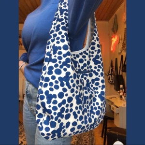 Vit handsydd tygväska med blåa prickar  - Många intresserade, buda gärna i komentarerna Handsydd tygpåse. Världens finaste blå prickiga tygväska med blå dragkedjsficka! Pris:160kr Frakt:40kr  Tyget är från en gardin som från början kommer ifrån afro art 