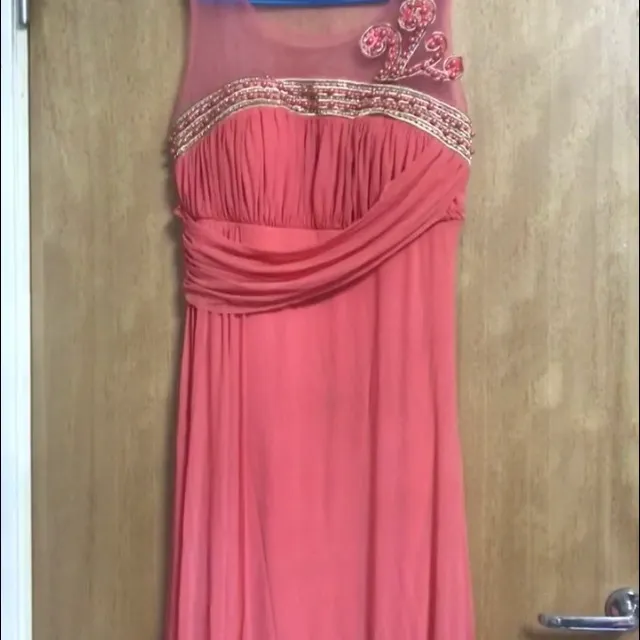 Klänningen är rödrosa och har pärlor som detaljer i rosa. Klänningen har rosor och har storleken 42 och kostar däremot 500kr . Klänningar.