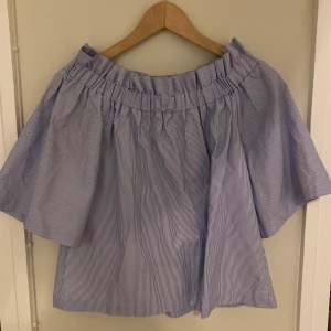 Blåvit randig blus - Blåvit randig sommarblus off shoulder, knappt använd, storlek 34. Riktigt söt på. Säljer för 100kr