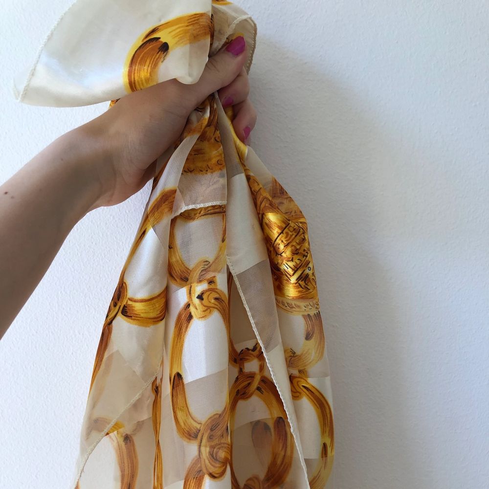 Vit scarf med ett mönster med guldkedjor, ca 1x1 meter. Köpt på humana men har inte fått nån användning för den. Möts i Stockholm annars betalar köpare frakt. . Accessoarer.