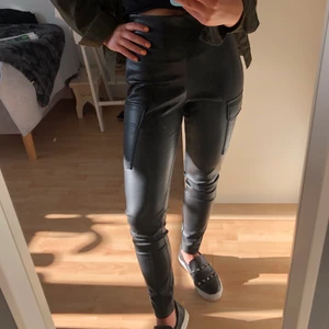 Skinnbyxor från Zara - Skinnbyxor (fake skinn) från Zara. Högmidjade. Detaljer som fickor och silvriga knappar typ längst ner. Väldigt sköna med tunt fleece inuti. Knappt använda därmed bra skick. Stl Xs