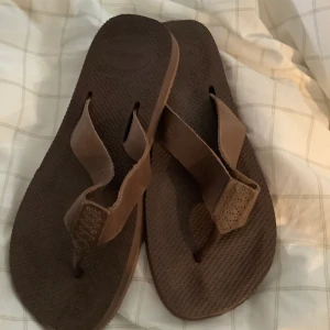 Havaianas flip-flops 39-40 - Halva priset! Nypris ca 450kr Snygga bruna flip-flops med remmar i brunt skinn. Ergonomisk sula, sköna att gå i! Köptes i Havaianasbutik på Bali. Helt oanvända, som nya! Storlek 39-40, usa 8, unisex 