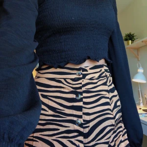 Djurprintad kjol - Säljer en cool långkjol från Nelly med djurprint! Prislappen är fortfarande kvar och den är helt oanvänd, köptes för 299 men säljer för 90 kr + frakt på ca 40 kr! Bilden i mitten visar längden, jag är typ 1.79 och den går till mitten av smalbenet!🥰🥰