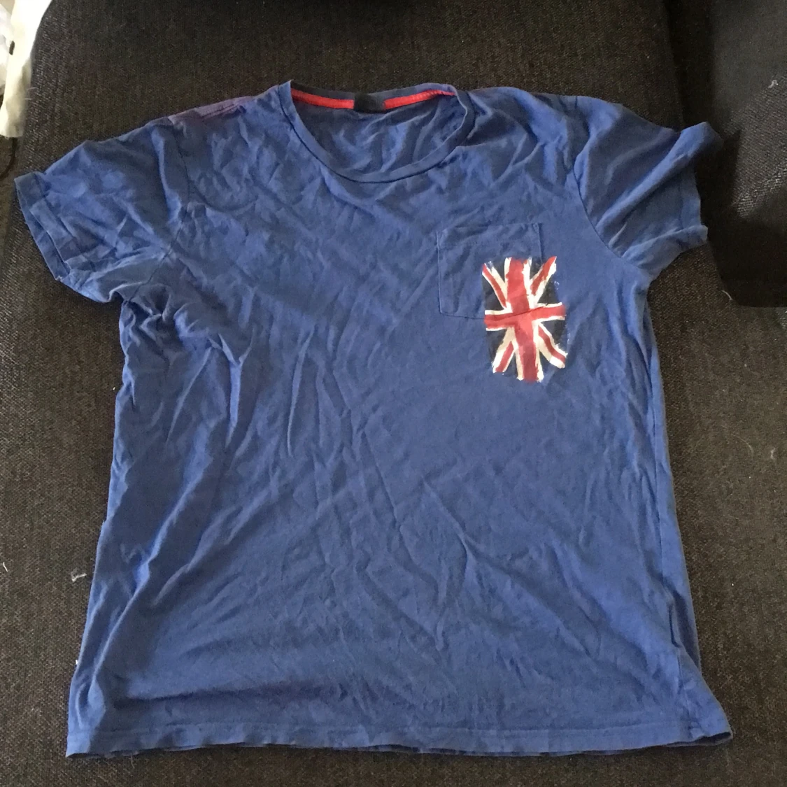 Blå T-shirt med kryck vid ena bröstet