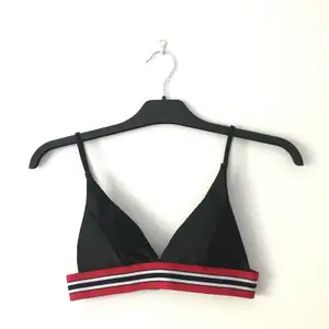 Svart bikini med röda resårband. Stort knäppe i ryggen (se 2a bild). Säljer pga att den ej passade. Aldrig använd, endast testad med kläder under. 