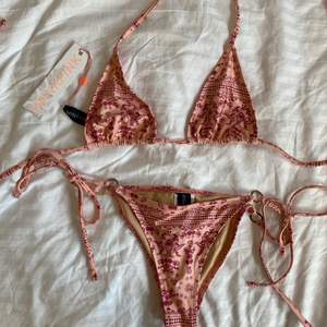 En fin rosa bikini med mönster🌸! Bikinin är aldrig använd och är i storlek S (både över och underdelen). Är köpt i en NAKD OUTLET märket är SWIM MINKPINK. Köparen står för frakten.💕🌷