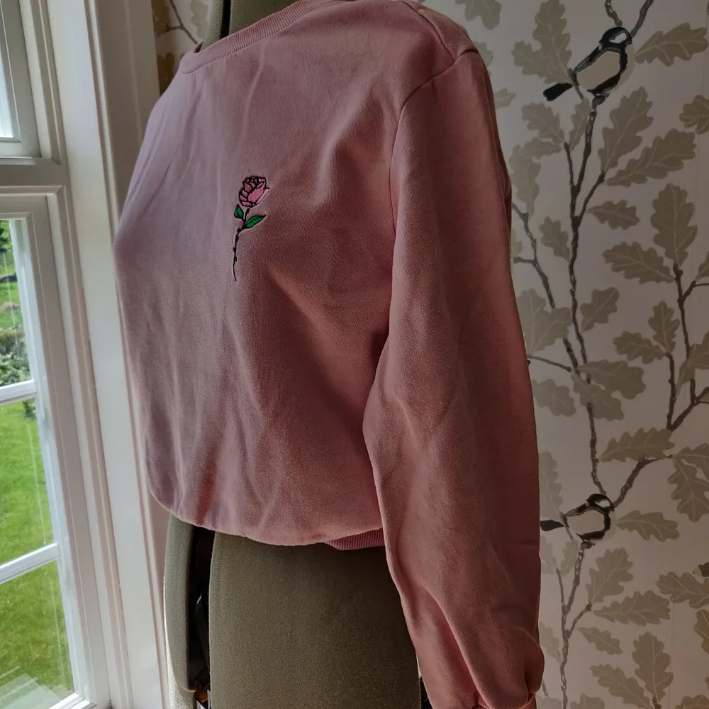 Rosa tröja från HM med briderat rosmitiv på bröstet. Bra skick, 50kr +frakt. Tröjor & Koftor.