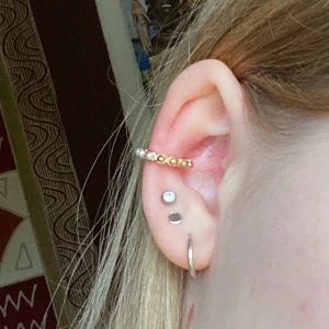 Earcuff! - Jättefin guldig earcuff (ej äkta guld). Små pärlor och guldiga pärlor (ej äkta) runt om! 30 kr inklusive frakt!!