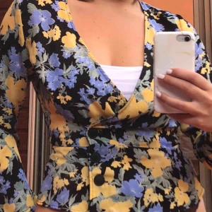  - Världens finaste blommiga omlottblus! Den är i tunnt material men man ser inte igenom. Den knäpps med knappar i midjan. Säljer pga att den är obekvämt tight runt brösten på mig. Pris kan diskuteras!