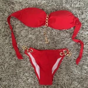Helt ny bikini med guldiga detaljer  - Helt ny (trosskydd fortfarande på), färgen är lite mörkare röd än på bilden, väldigt fin! Fina guldiga detaljer som kedjor och lite smycke. Köp den om du vill bli snyggaste på stranden 😉 Frakt ingår