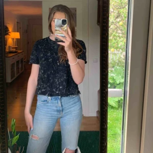  - En gråmelerad kortärmad tröja med öppen rygg. 