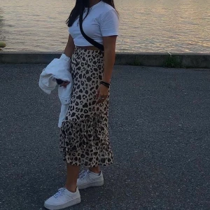Leopardkjol med elastiskt band i midjan - En superfin och skön kjol från KappAhl i leopardmönster. Den har flera lager av tyg för att den inte ska vara genomskinlig! Strass i midjan och passar därför många olika storlekar. Använd få gånger, Max 5. Köptes för 450kr
