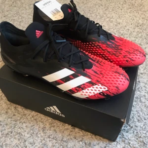 Adidas fotbollsskor  - Helt nya fotbollsskor från Adidasbyxor, aldrig använda i storlek 45 1/2. Modell: PREDATOR MUTATOR 20.1 L FG Möts upp på söder eller i Stockholm, köpare står annars för frakt.
