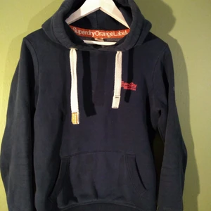 As fin hoodie från superdry - Denna hoodien är väldigt tjock och i jättefint skick. Den är mörkblå och har rosa och orange detaljer. köparen står för frakten ❤️