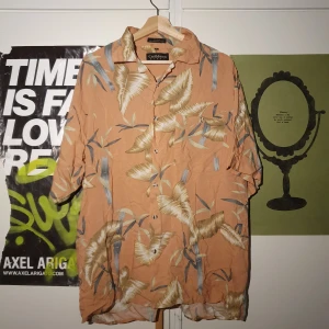 Rosa Hawaiiskjorta - Väldigt trendig och cool korallrosa hawaiiskjorta köpt på popbutique i gbg. Jättebra skick. Passar perfekt till sommaren. Köparen står för frakten. Samfrakt erbjuds.Köparen står för frakten. Samfrakt erbjuds.