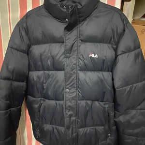 Fila puffer - En puffer jacket från fila i nyskick! Dragsko insatt så den går att dra åt i midjan. Otroligt mysig jacka men kommer inte till användning hos mig tyvärr. 300kr eller bud i kommentarerna