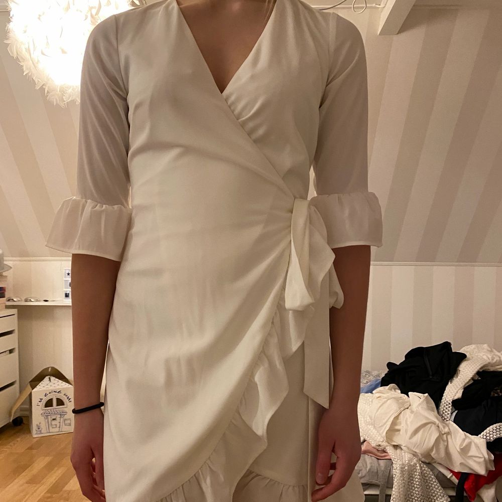 Väldigt fin klänning. Använd en gång. Perfekt till student eller liknande. Volanger från midjan som går neråt i en slits. Knytning i sidan. V-ringad. Trekvartsärmar med volanger i slutet av ärmen. Fint skick. Har även en likadan oanvänd till samma pris i strl M!. Klänningar.