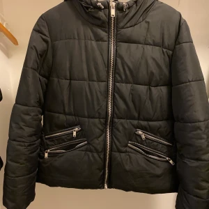 Svart jacka - Svartjacka med silver detaljer. Sammanlagt två fickor.