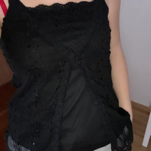 Svart linne - Snyggt linne med tyll och paljetter. Banden är lite långa så jag brukar knyta upp dem. Storleken är 158/164 men jag skulle säga att den passar XS/S. Jag står för frakten!😊 OBS köp 3 plagg (50kr) betala 100kr PLUS jag står för frakten!😊😍❤️