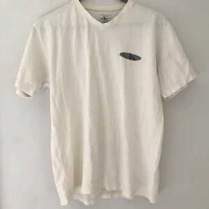 Calvin Klein vit oversized t-shirt💛 - Oversized t-shirt från Calvin Klein. Köpt second-hand så kan ej garantera att den är äkta. Har några småsmå fläckar på ryggen💛💛💛 Kan mötas upp i Stockholm annars tillkommer fraktkostnad:)