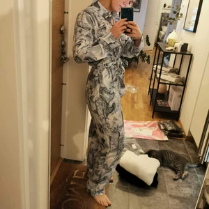 Blå jumpsuit från Monki  - Blå jumpsuit från Monki, köpt för 450kr. Använd endast 1 gång. Väldigt cool med olika statyer som motiv! Jätteskönt material. Kommer tyvärr inte till användning. 