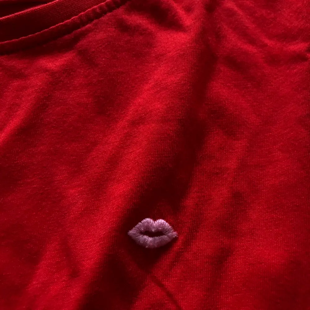 En fin, röd, somrig t-shirt med en rosa pussmun på! Härligt mjukt, material. Storlek S. Använd ett par gånger så det är en fin kvalitet på tröjan. . T-shirts.