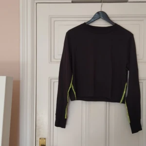  - Långärmad, svart tröja med neongröna revärer från Cheap Monday.  Mycket sparsamt använd! 100% ekologisk bomull✨  