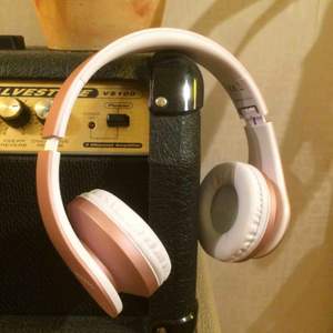 Ett par rosegold Bluetooth hörlurar med ok kvalite laddare och sladd ingår