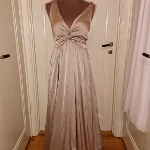  - Ny balklänning med lappen kvar från nelly, superfint glansigt champange/beige material. Storlek 34. 36kr i frakt betalning via swish 