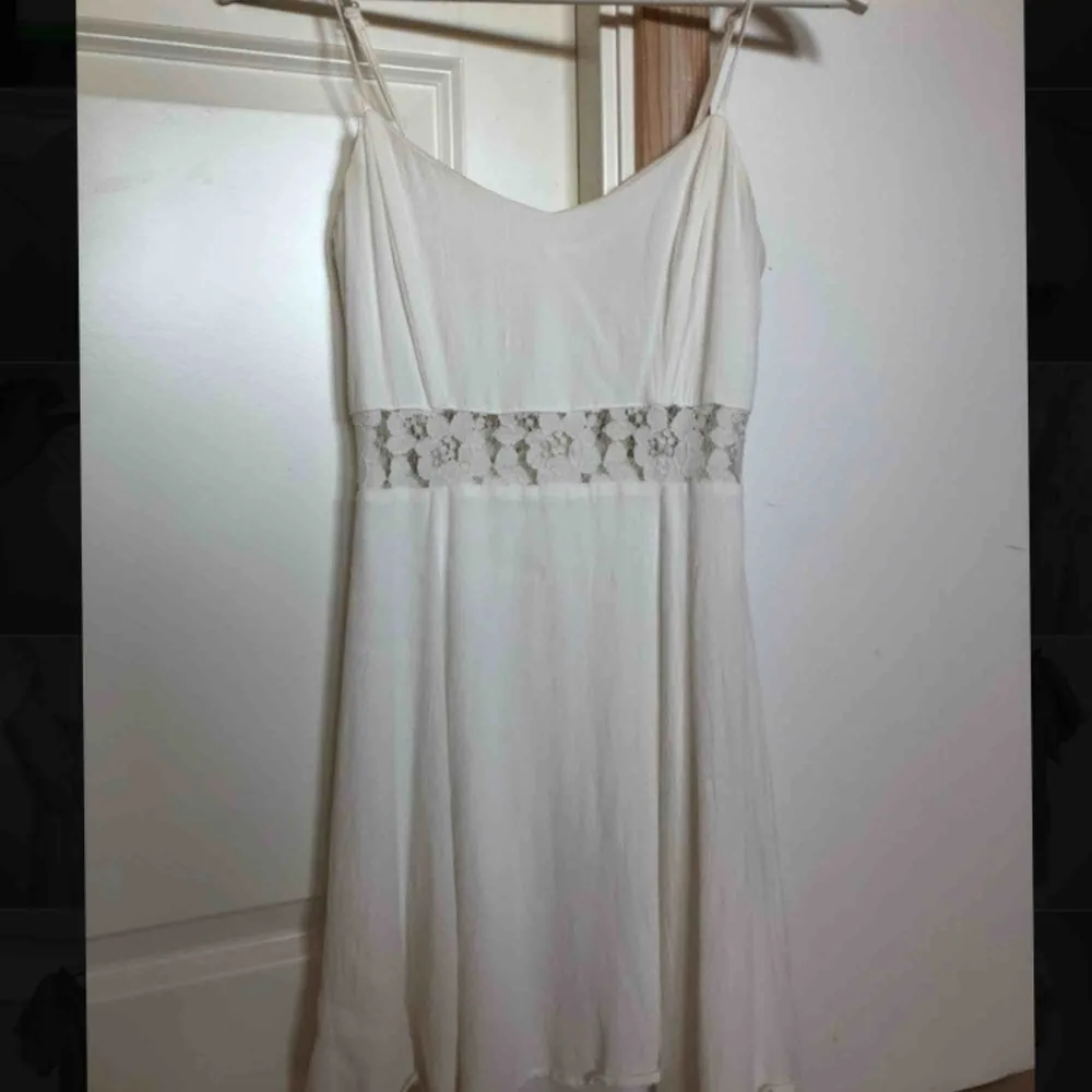 Vit klänning med spetsdetaljer, använd vid två tillfällen, säljer pga för liten. Klänningar.
