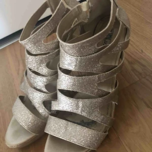  - Guldiga klakisar med dragkedja bak, använda några gånger så har några få svarta märken i sulan men annars i super fint skick :)