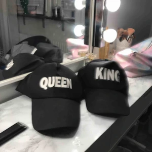  - 2 svarta kepsar med en vit text på båda och på den ena står det Queen och på andra king Kostar 20kr + frakt som kostar 29 kr för båda tsm aldrig använda fint skick jätte fina ;)  