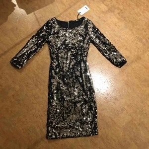 Paljettklänning  - Helt oanvänd, prislappen sitter kvar. Köparen står för frakten, kan även mötas upp i Malmö.