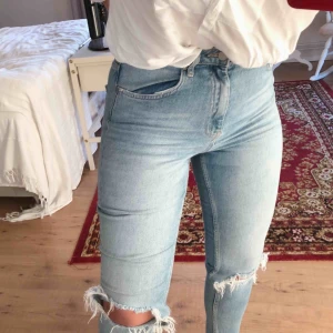  - Ljusa Jeans i ”straight” modell med hål i knän. (Frakt ingår ej)