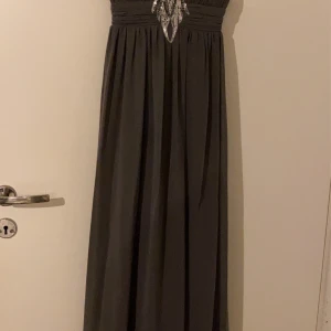 Grå klänning stl xs - Säljer min klänning med paljetter mellan bysten. Den är  använd endast 2 gånger 