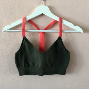 Sporttopp från Adidas - Grön sporttopp från adidas med knalliga orangea band. 