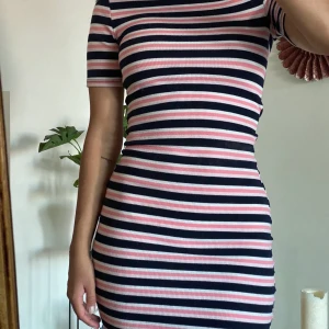 Randig klänning - En rosa, blå och vit randig klänning från H&M dividend. Är i storlek 32 men stretchar så borde passa någon som har 34 oxå ❣️ Frakt tillkommer alternativt mötas upp vid TC eller Hötorget :)) 