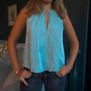 Blått siden/ satin linne - Assnyggt ljusblå/ turkos aktigt satin/ siden linne! Lite öppet i ryggen med knytning. Har dock inte kommit så mycket till användning tyvärr. 160kr, köparen står för frakten.