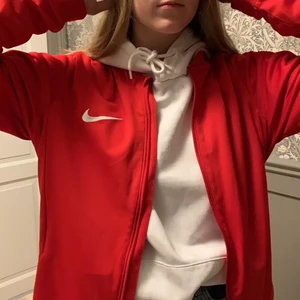 Röd Nike - Jätte trendig tränings jacka som passa perfekt både att ha som enskild tröja och över något annat som på bilden. Inga defekter och knappt använd. Skriv privat för fler bilder. Köpare står för frakt. Min flickvän på bilden är 168cm och bär oftast XS/S i tröjor. Så på mig som är 184cm och när en M är den mer fast.