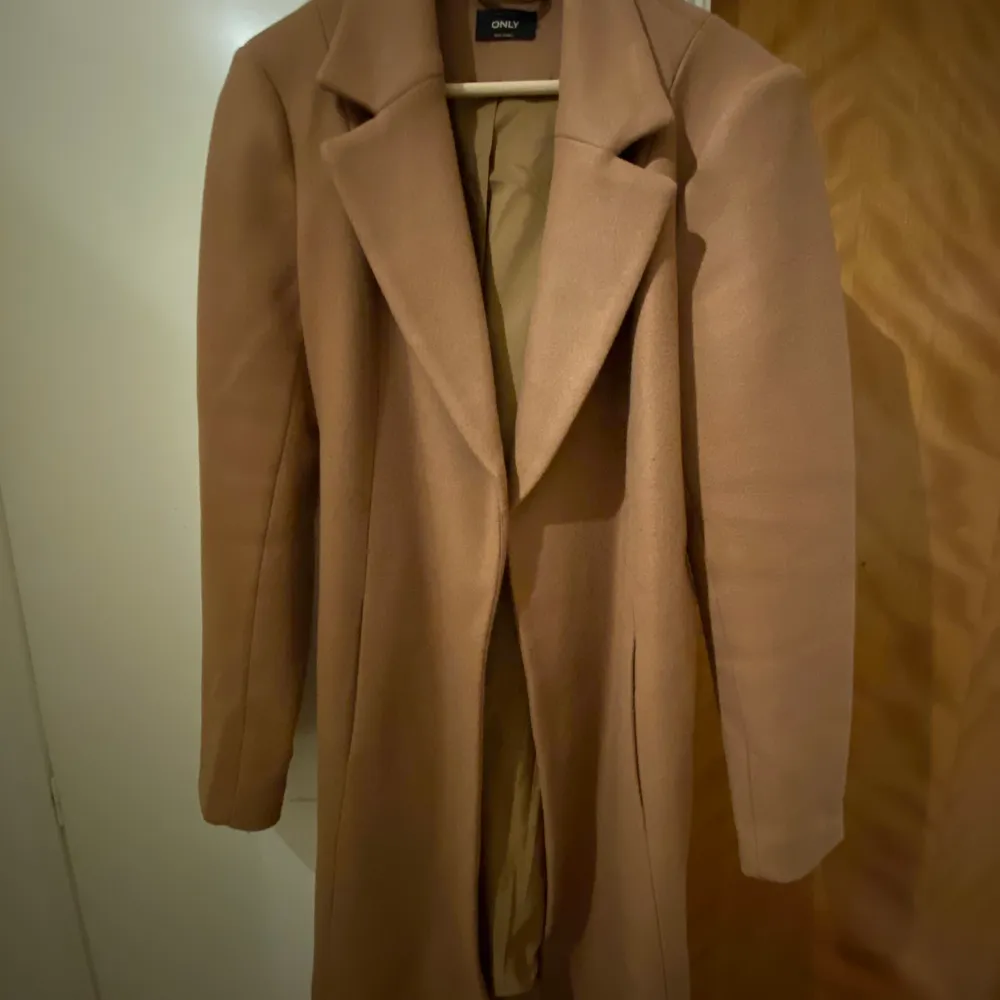 Brun kappa i färgen ”camel” köpt på Zalando. Takit.