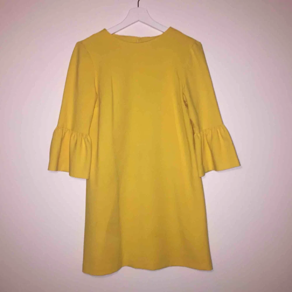 Härlig gul klänning med volangärmar! I storlek S från Zara. Den har några små, knappt synbara, fläckar som framgår av sista bilden. . Klänningar.
