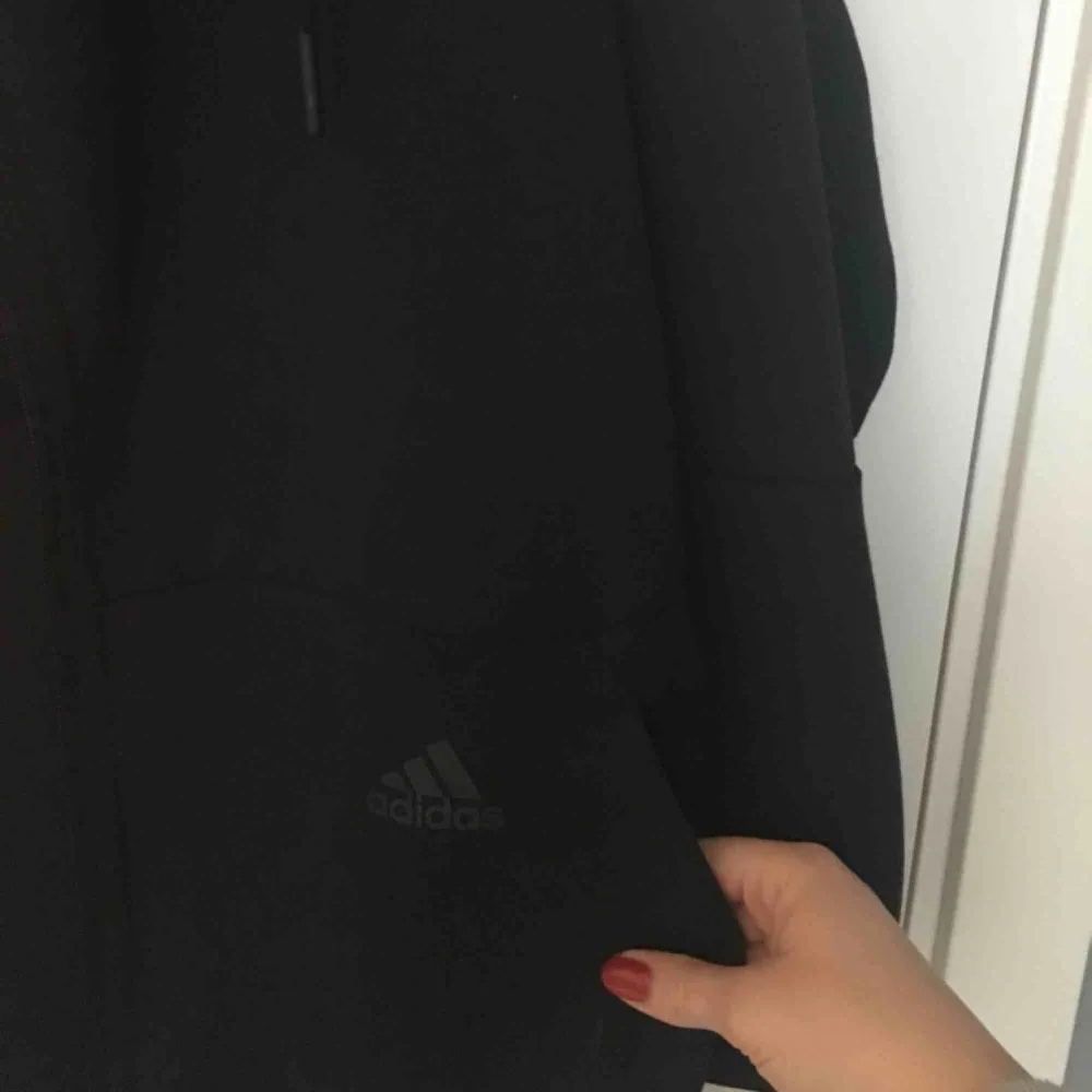 Svart Adidas hoodie i storlek S i NYSKICK! Köpte den på NK sports i Göteborg för ett halvår sedan. 200 kr inklusive frakt, skickar inom ett dygn! . Hoodies.