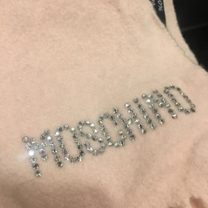 Moschino halsduk - ÄKTA!! Unik moschino halsduk som är gjort av ull, MOSCHINO skrivit med strass 💓.  Likadan scarf i svart är värderad till 2000kr
