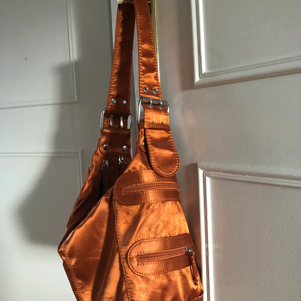 Säljer denna sjukt fina väska från ASOS som är lite metallic orange, måste sälja pga för lite användning.. den är som ny endast använd 3ggr. Jätte praktiskt med två fack i väskan + många ytterfickor! 150kr. Väskor.