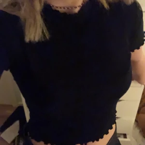 snygg topp - en svart topp i riktigt skönt material med volanger vid alla sömmar. Som ny!! Vet inte märke köpt second hand<33               S i storlek men stretchig