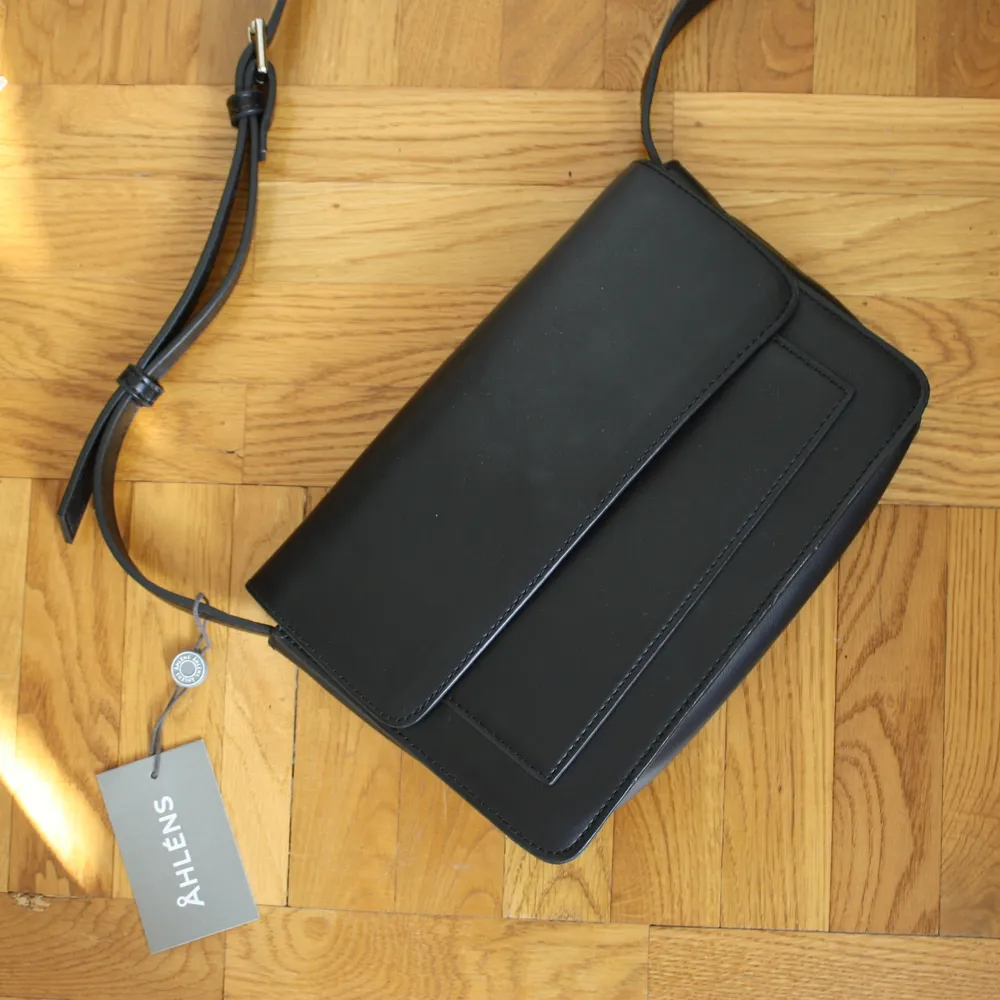 En liten, svart handväska i konstgjort läder. Helt ny och aldrig använd. Nypris 349 kr. Många bra fack, perfekt storlek för en utekväll! Hör av dig om du är intresserad:)). Accessoarer.