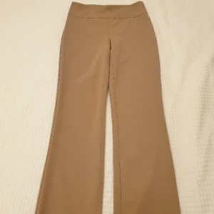 Eleganta byxor som passar flera tillfällen! - Jättefina beige byxor med hög midja och lite bootcut. Har en snygg passform och passar med t.ex. vita sneakers eller likaså högklackat.  Gillar dessa jättemycket men passar inte längre. Jag är 163 cm och byxorna slutar ungefär vid fotknölarna. 